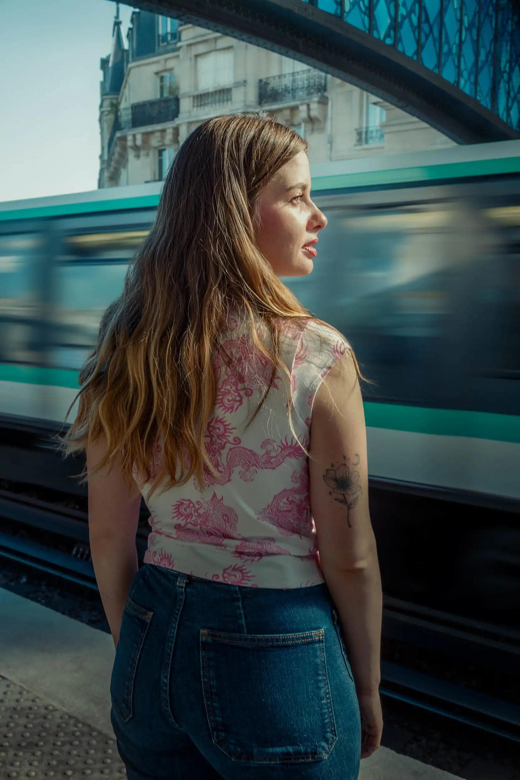 Portrait d’une femme devant un métro en mouvement au pont de Bir-Hakeim, Paris, photographie cinématographique inspirée d’Inception réalisée par Arthur Monteil.