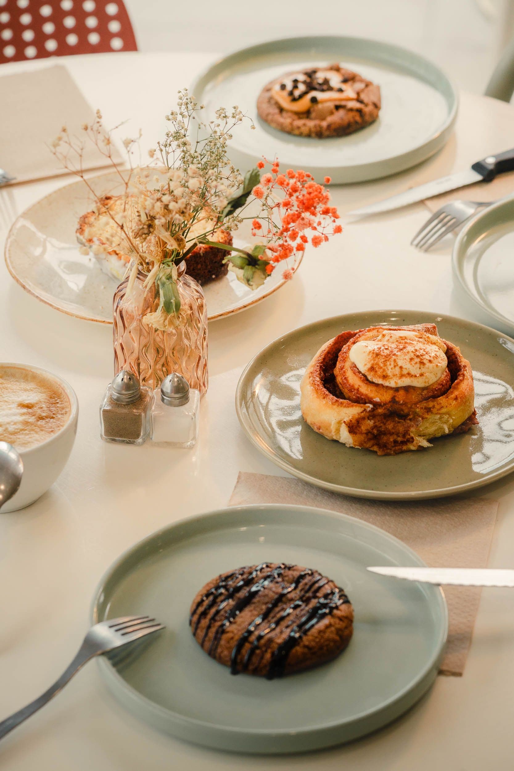 Cinnamon roll artisanal avec glaçage et fleurs séchées, photographie culinaire pour Amanah Coffee Shop à Bussy-Saint-Georges par Arthur Monteil