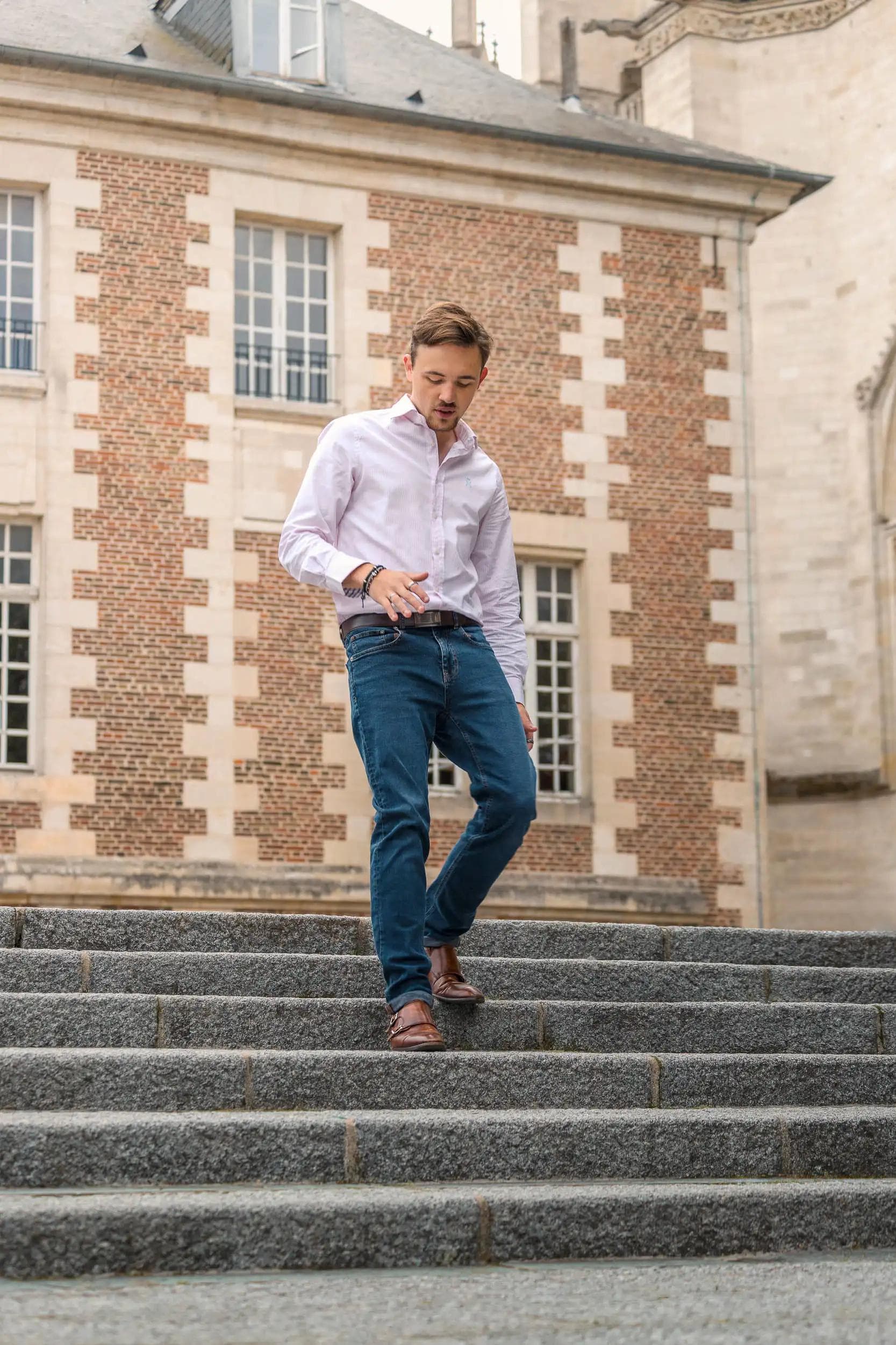 Portrait éditorial d’un homme descendant des escaliers en centre-ville d’Amiens, capturé par Arthur Monteil dans un style mode naturel.