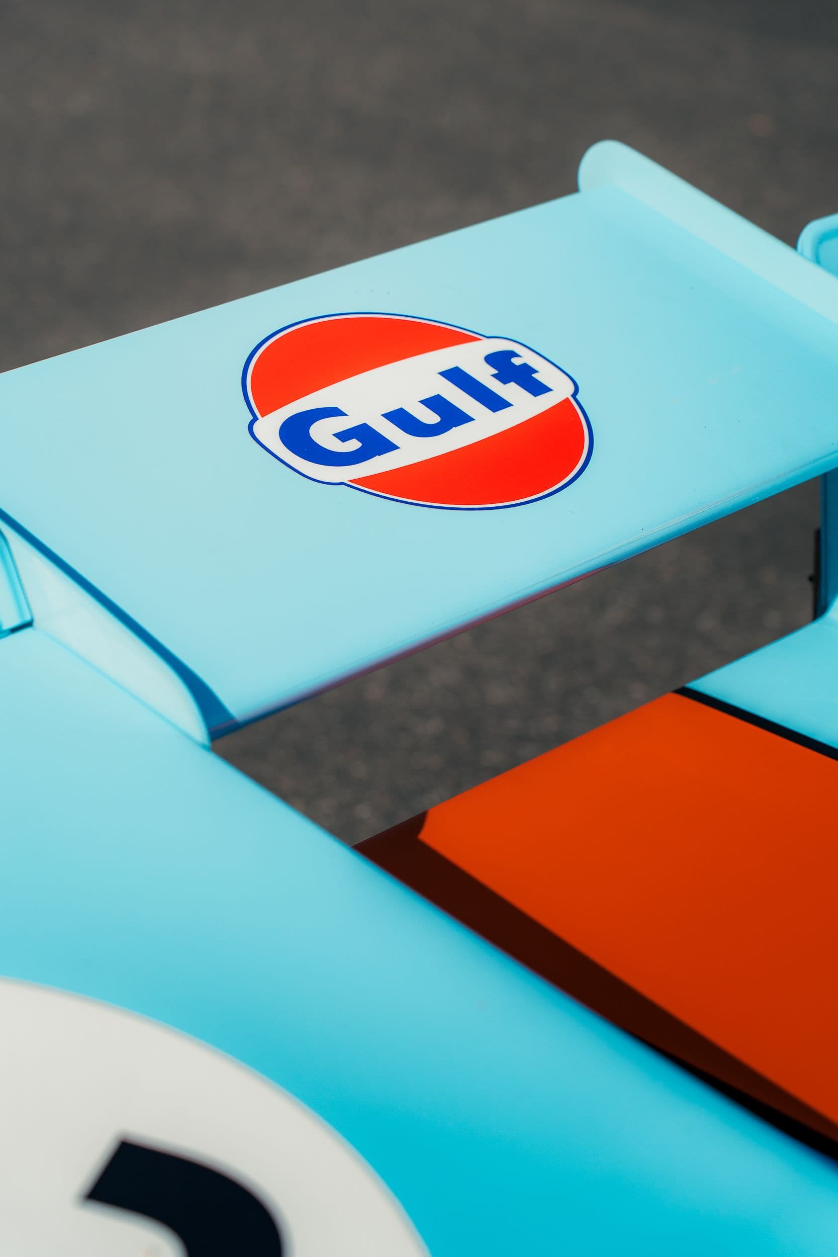 Logo Gulf sur l’aileron bleu clair d’une Porsche 917 Replica, au-dessus de la bande orange.