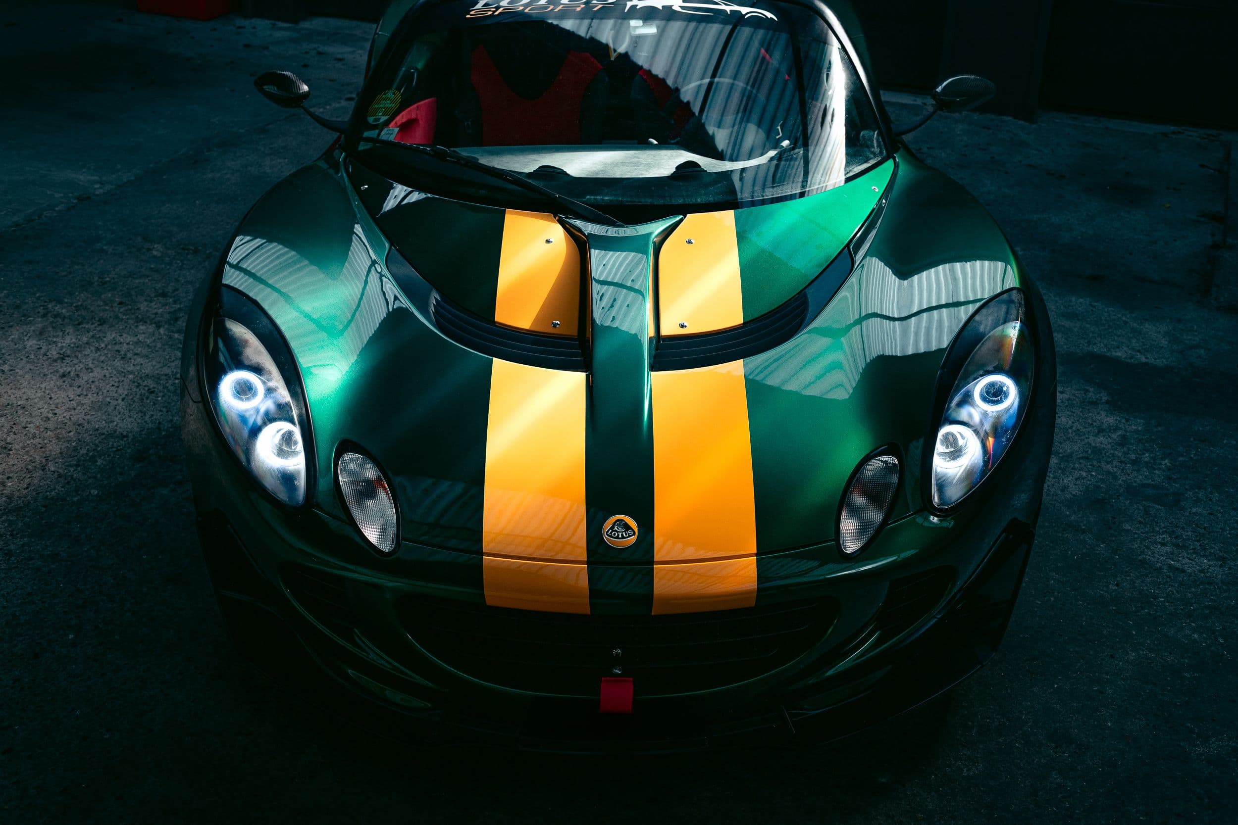 Lotus Elise S2 vue de face en plongée, bandes jaunes et phares allumés sous verrière
