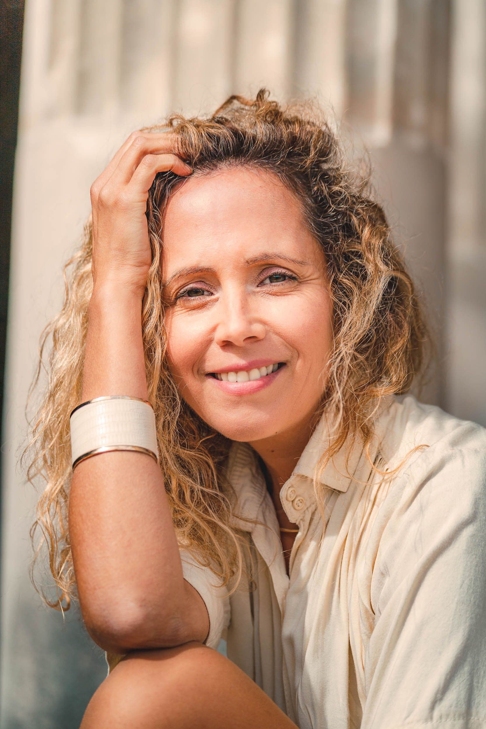 Portrait rapproché au pied d’un monument, expression naturelle et paisible.