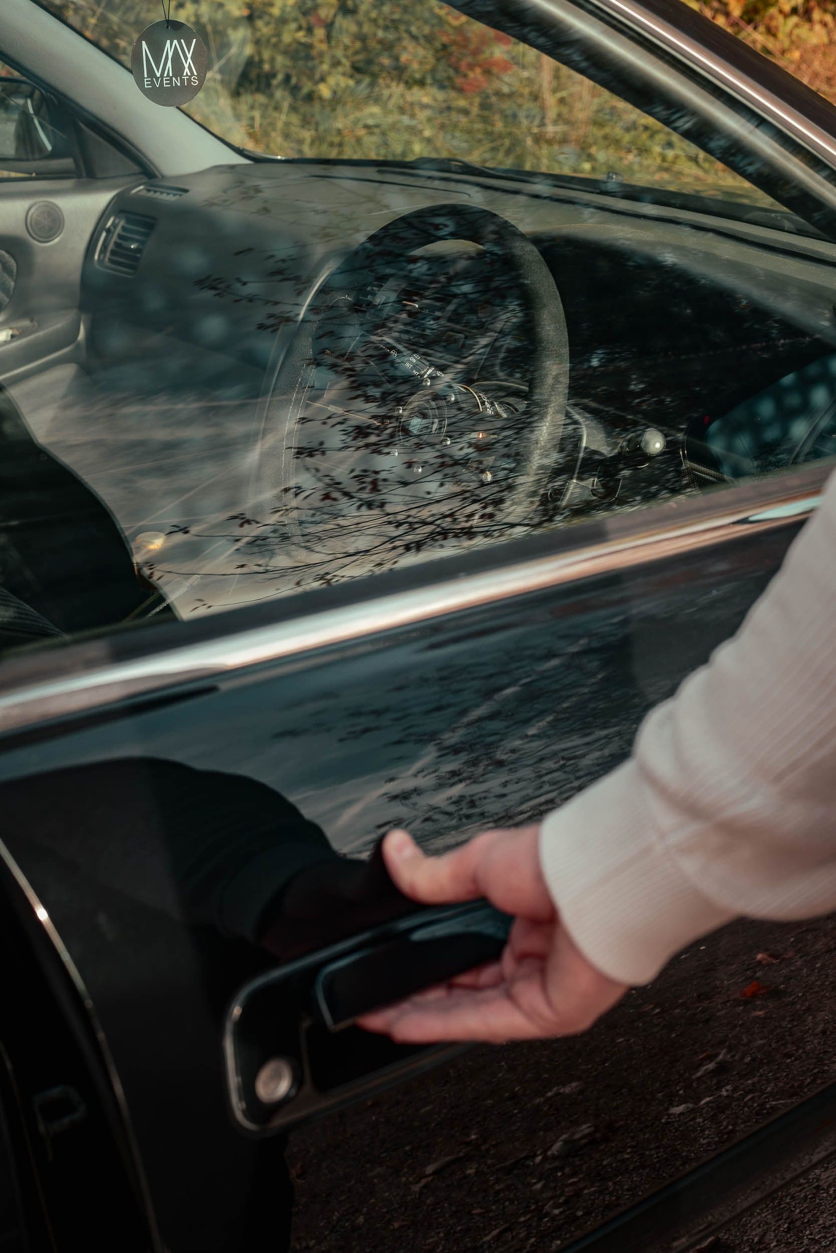Reflet artistique dans vitre latérale Toyota Chaser JZX100 avec volant visible, photographie automobile créative berline JDM