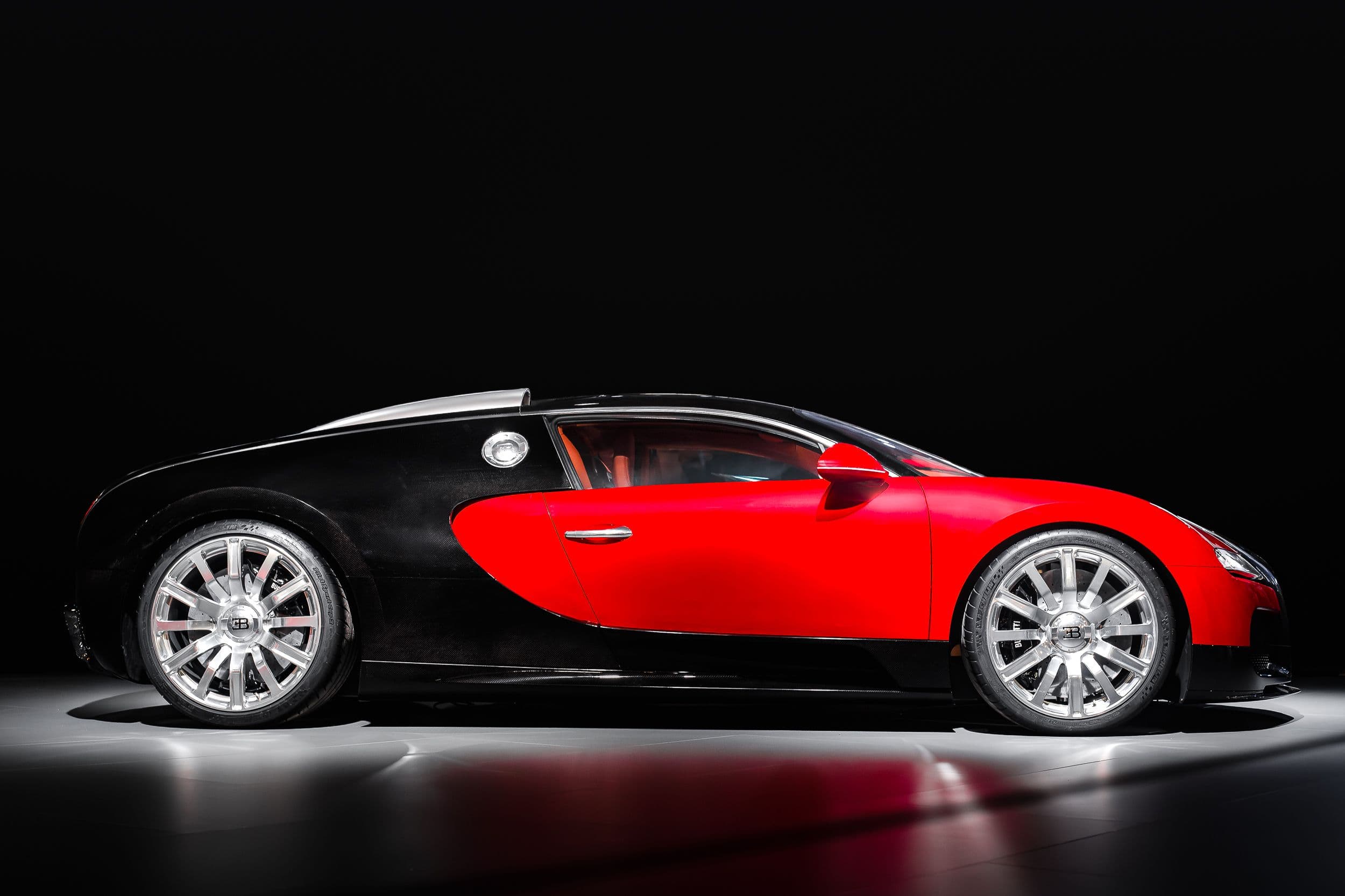 Vue de profil de la Bugatti F.K.P Hommage, mettant en valeur les jantes et la carrosserie rouge, au Rétromobile 2026.