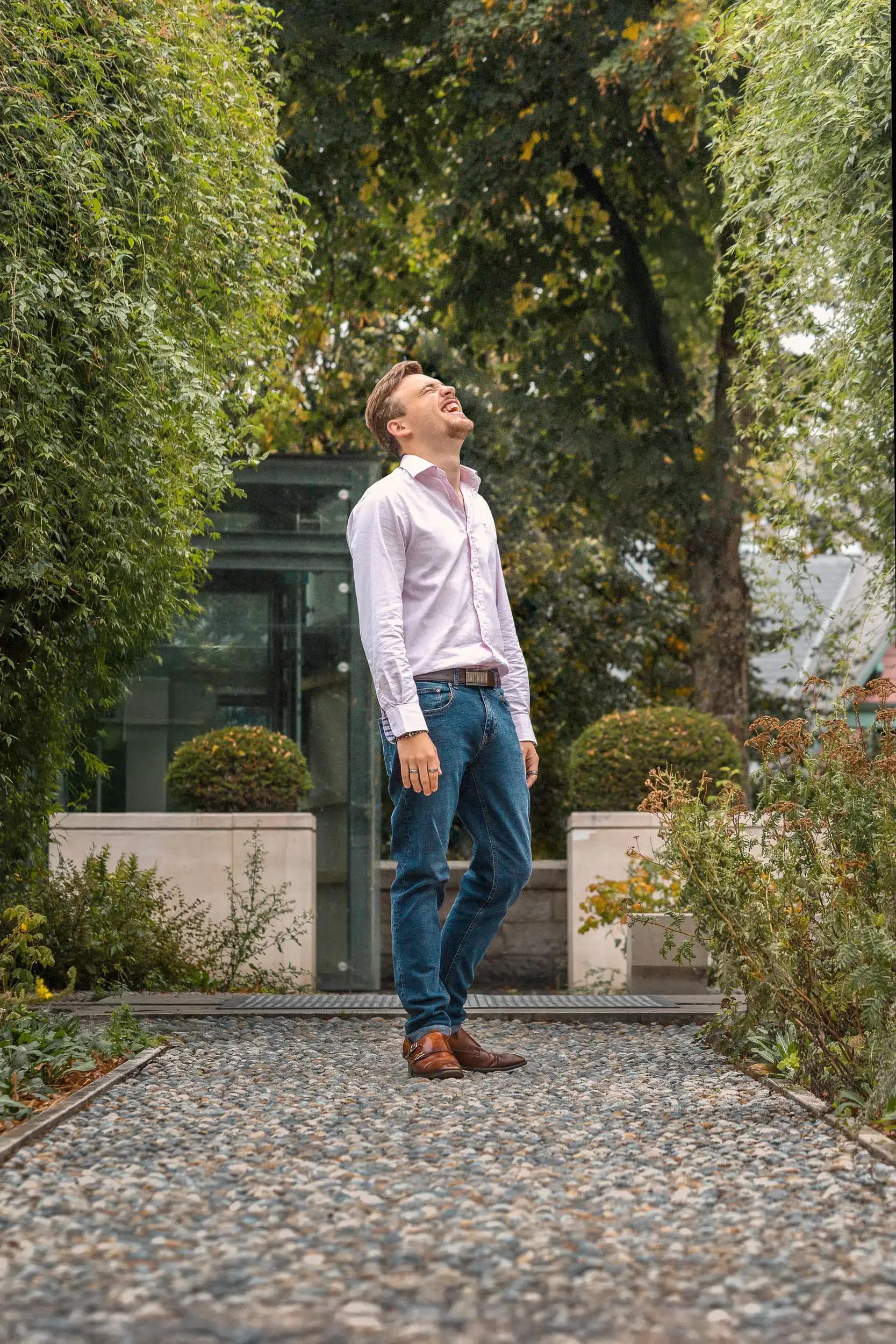 Portrait lifestyle d’un homme riant en plein air dans un jardin à Amiens, photographie mode au style naturel et élégant réalisée par Arthur Monteil.