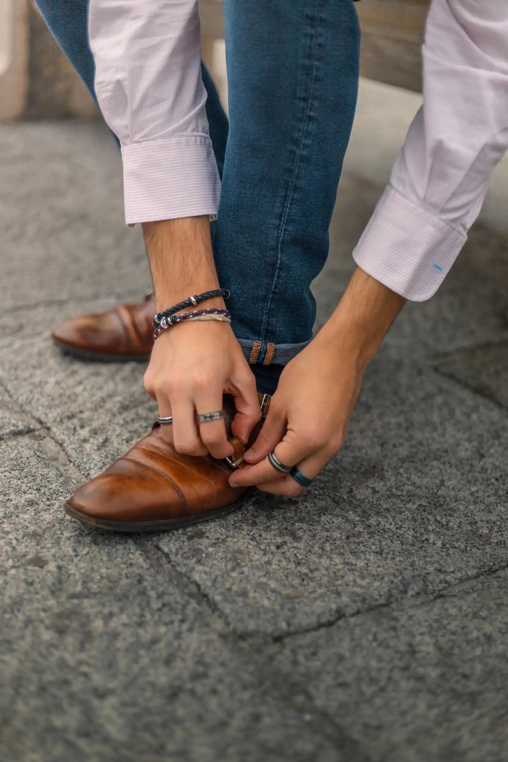 Gros plan lifestyle sur les chaussures et les mains d’un homme ajustant sa boucle, photographie éditoriale réalisée à Amiens par Arthur Monteil.
