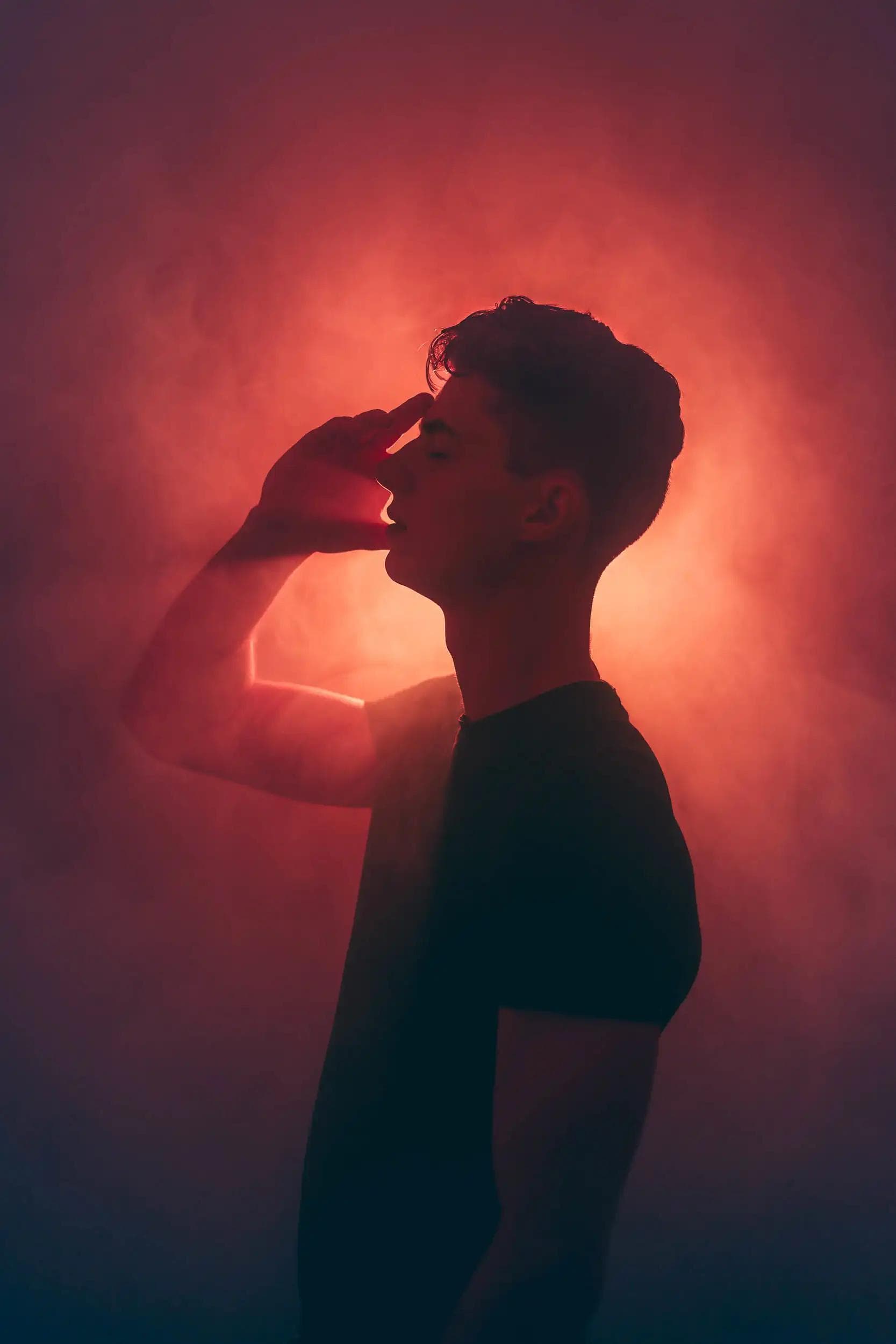 Silhouette en autoportrait éclairée d’une lumière rouge intense, série Chrysalis.