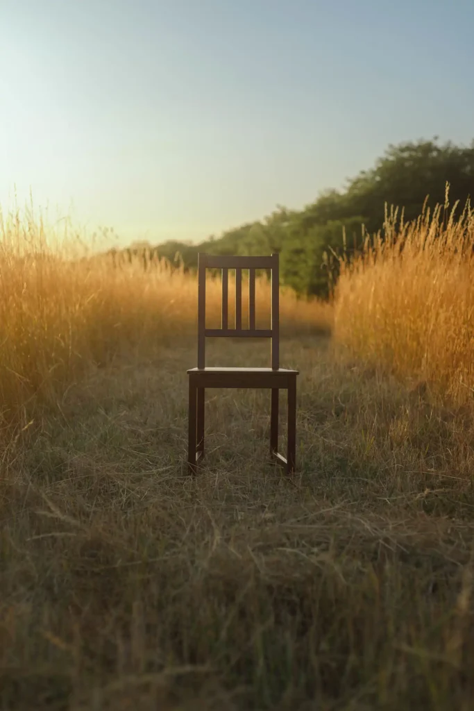 Chaise seule au milieu d’un champ doré, lumière chaude et minimalisme visuel.