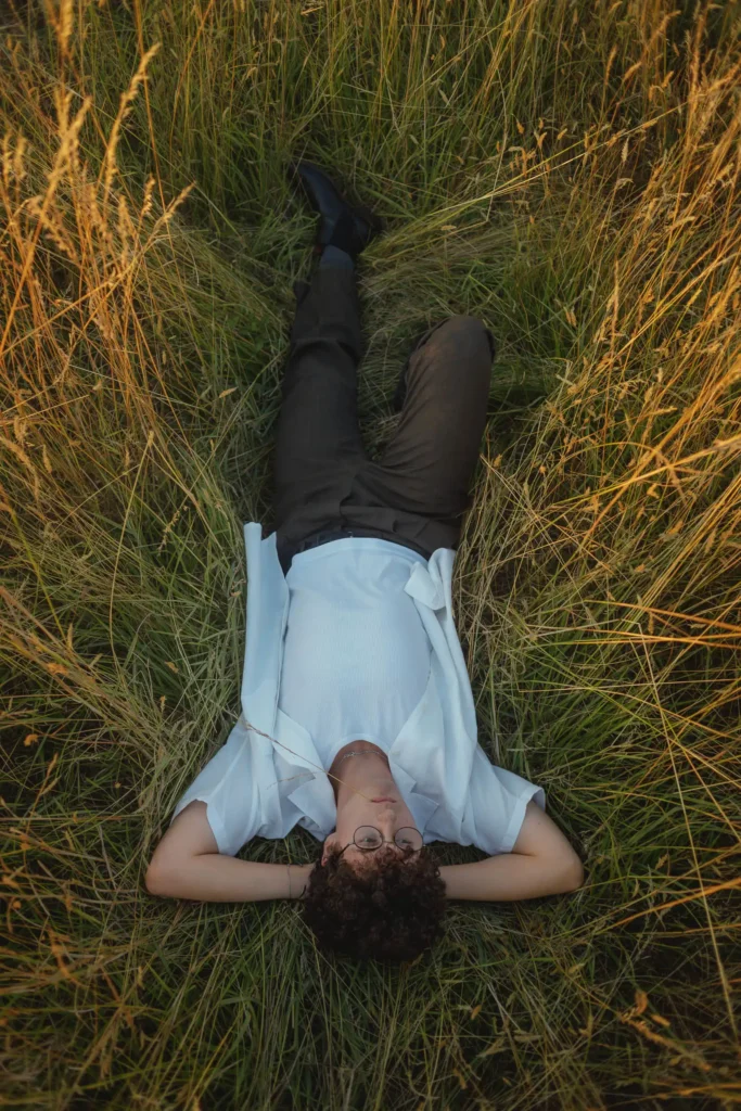 Modèle allongé dans l’herbe d’un champ à Bussy-Saint-Georges, ambiance naturelle et reposante.