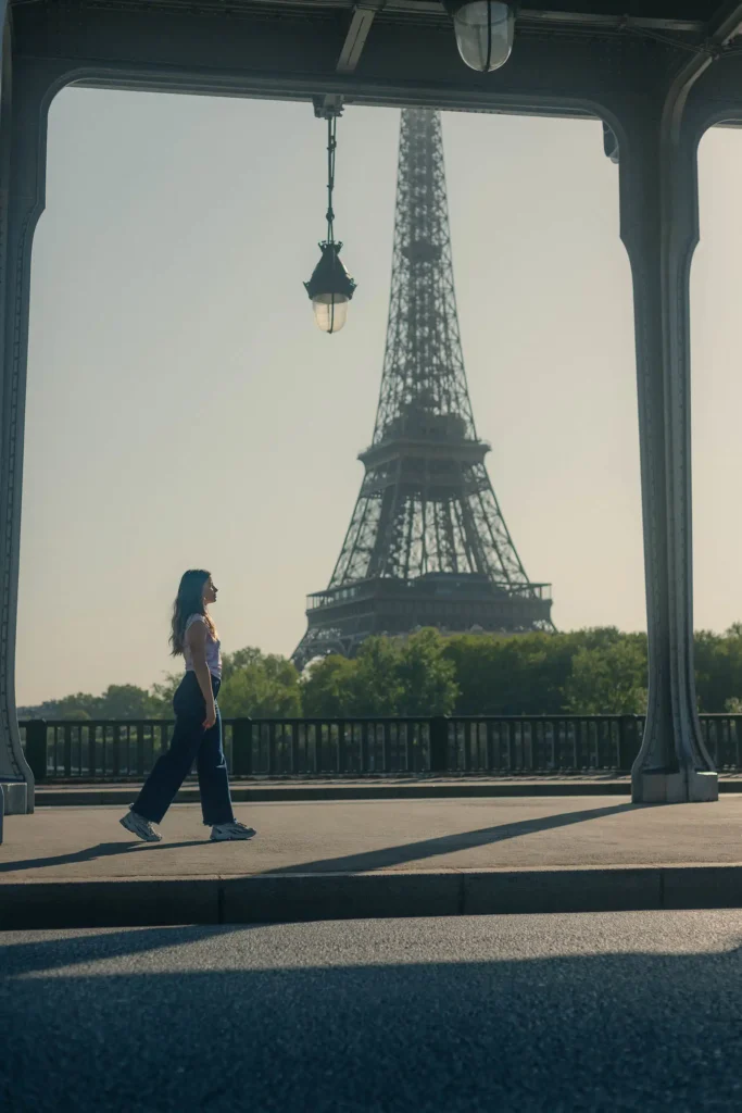 Portrait d’une femme marchant au pont de Bir-Hakeim avec la Tour Eiffel en arrière-plan.