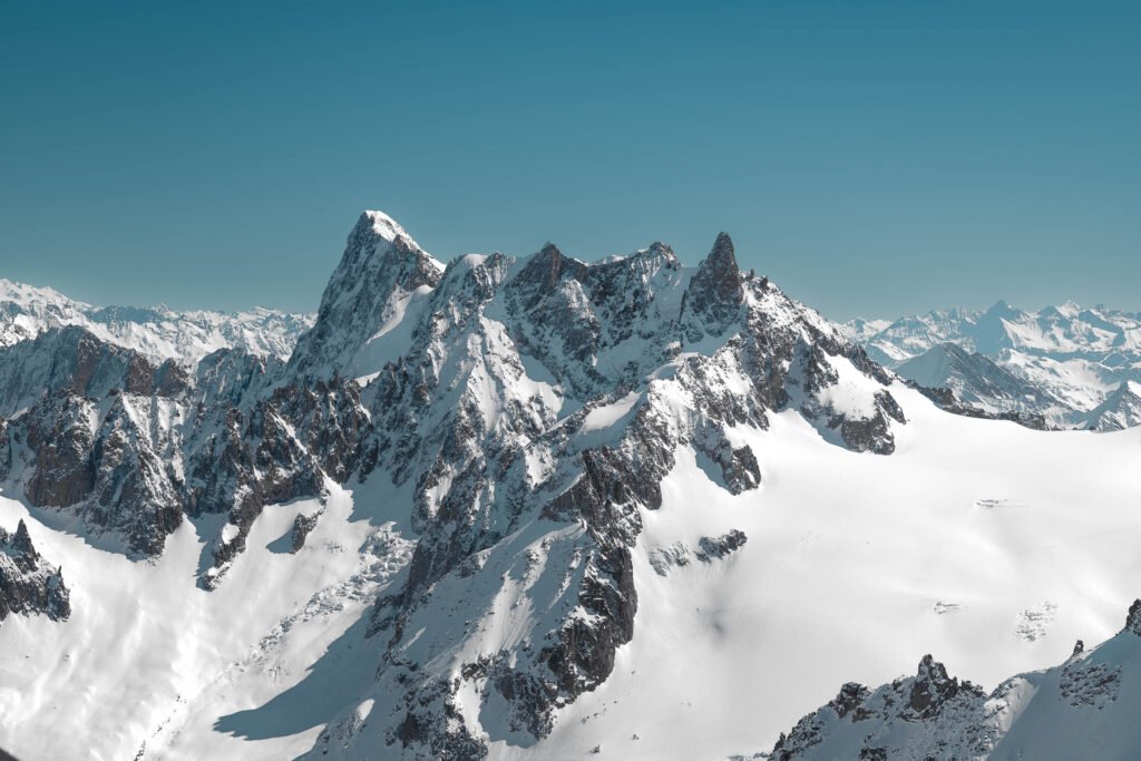 Pic rocheux alpin dominant un plateau enneigé